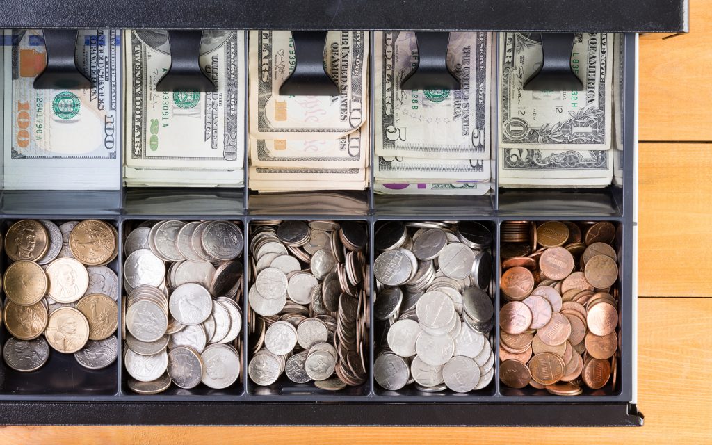 Top down view on single cash register drawer stocked full with