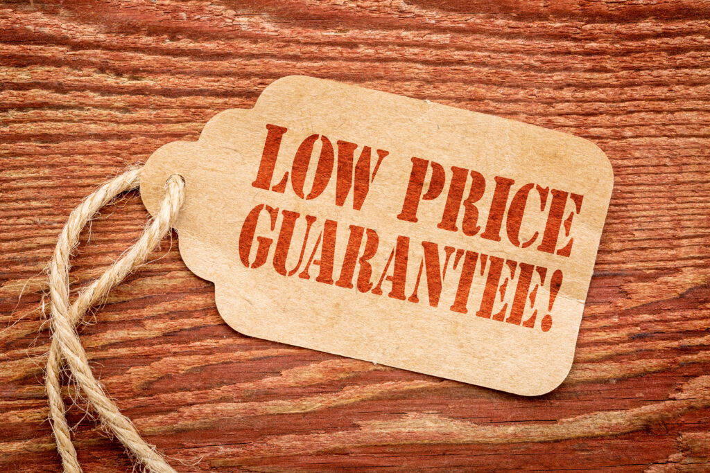 low price guarantee - sign on paper price tag against a rustic barn wood