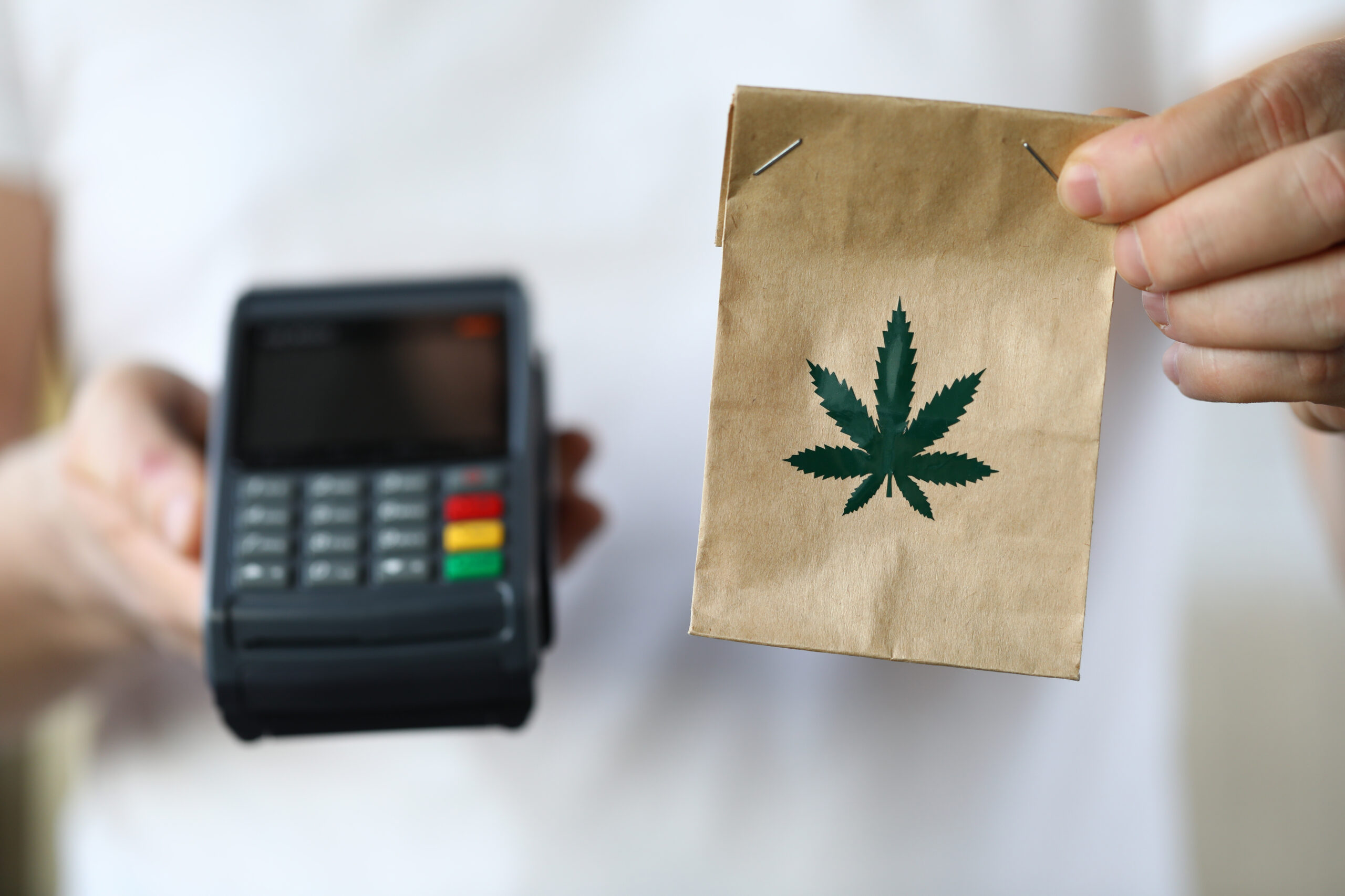 Package delivery with a brown bag of marijuana and a payment terminal.